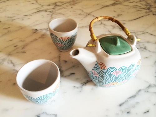 a white vase and two cups on a counter at Hortensias in La Croix-Helléan