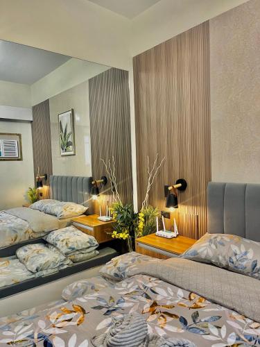 a hotel room with two beds and a mirror at Amani Grand Resort Residences Pool Netflix Gym near Airport in Lapu Lapu City
