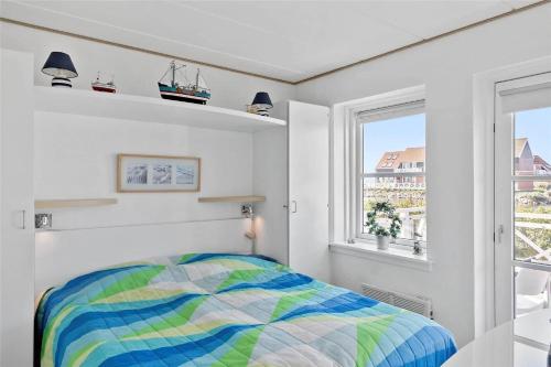 ein Schlafzimmer mit einem farbenfrohen Bett und einem Fenster in der Unterkunft 4106 Borre - Klintholm Havneby 6 in Borre