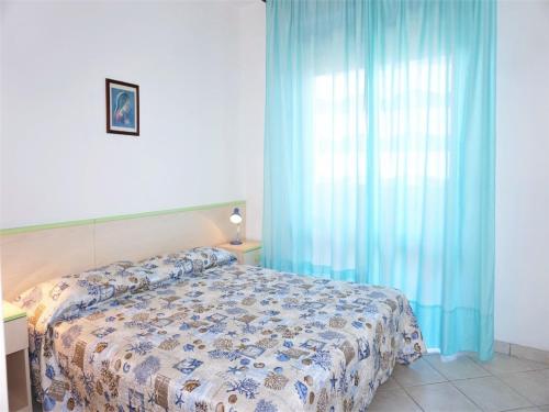 a bedroom with a bed and a blue curtain at Caorle Holiday Home with Terrace in Porto Santa Margherita di Caorle