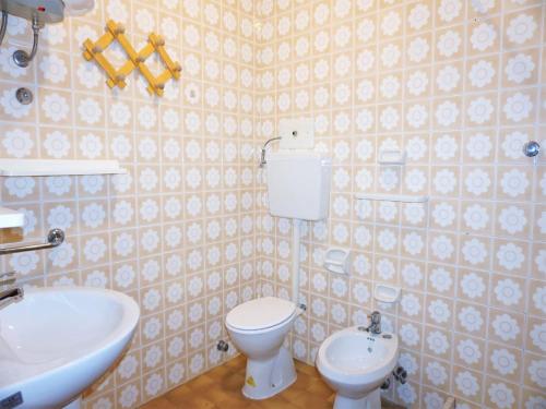 a bathroom with a white toilet and a sink at Caorle Holiday Home with Terrace in Porto Santa Margherita di Caorle