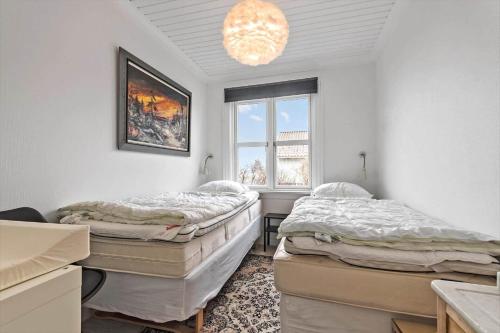 2 bedden in een kamer met een raam en een kroonluchter bij S701-Stroby-Kystvejen-164 in Strøby