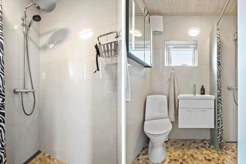 een witte badkamer met toilet en douche bij S701-Stroby-Kystvejen-164 in Strøby