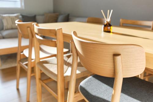 a wooden dining room table with two chairs and a table at 東川Hinna in Higashikawa