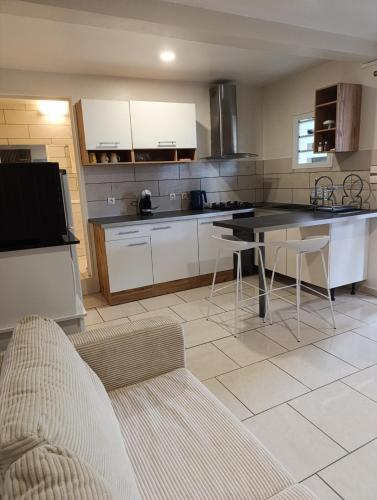 a kitchen with white cabinets and a table and chairs at Du Pure Cocooning in Saint-Philippe