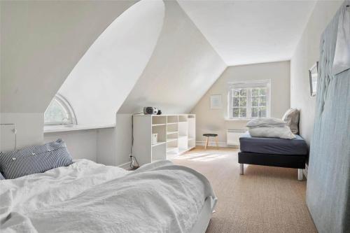 een witte slaapkamer met een bed en een raam bij 3302-Stege-Brakildevej-2 in Stege