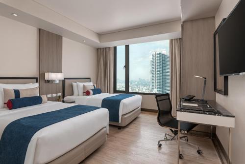 En eller flere senge i et værelse på Seda Residences Makati