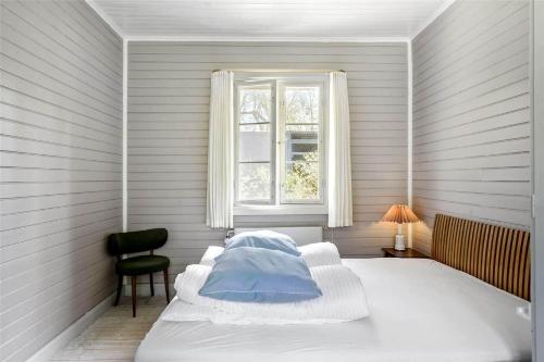 een witte slaapkamer met een bed en een raam bij S760-Stroby-Ladeplads-Spaettevej-14 in Strøby Ladeplads