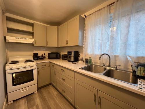 een keuken met een spoelbak en een fornuis bij Carlton House in Toronto