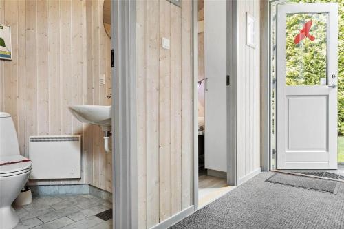een badkamer met een toilet, een wastafel en een deur bij 3313-Stege-Overlid-11 in Stege