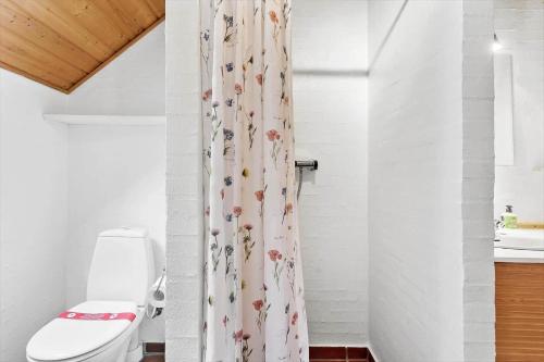een badkamer met een douchegordijn en een toilet bij 3034-Stege-Bundgarnet-34 in Stege