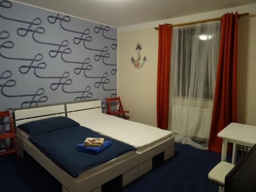 a bedroom with a bed and a wall with shoes on it at Penzion Eden Turnov in Turnov