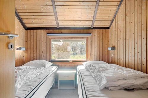 two beds in a room with a window at 3078-Stege-Maegleren-18 in Stege