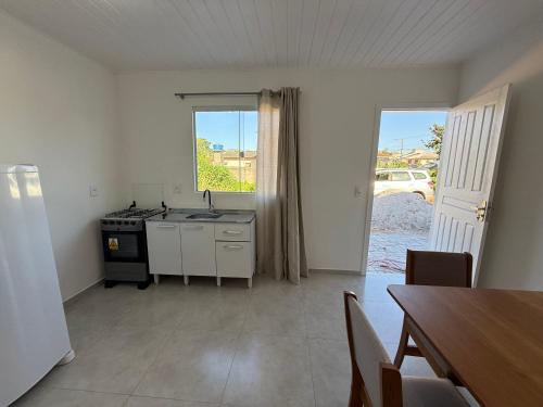 een keuken met een wastafel, een fornuis en een tafel bij Loft novo e bem localizado in Biguaçu