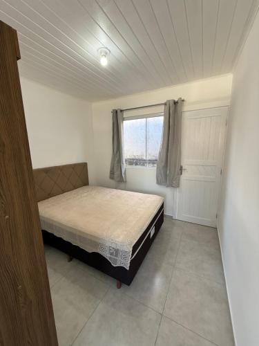 a bedroom with a bed and a window at Loft novo e bem localizado in Biguaçu