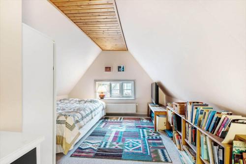 - une chambre mansardée avec un lit et un tapis dans l'établissement 4020-Stege-Udbyvej-10, à Stege