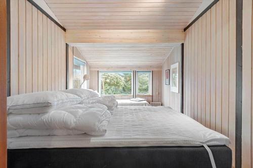 una camera da letto con un letto grande con cuscini bianchi di R957-Rodvig-Baeverdalen-5 a Rødvig