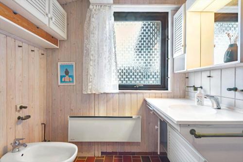 un bagno con lavandino, WC e finestra di R957-Rodvig-Baeverdalen-5 a Rødvig