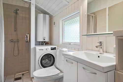 een badkamer met een wasmachine en een wastafel bij 3064-Stege-Maegleren-34 in Stege