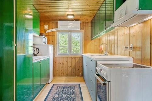 a kitchen with green and white cabinets and a window at 7057-Bogo-By-Mollebakken-67 in Bogø By