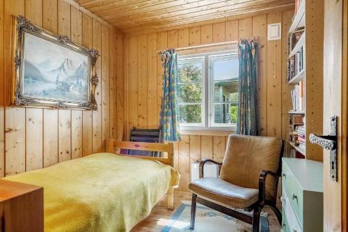 a bedroom with a bed and a chair and a window at 7057-Bogo-By-Mollebakken-67 in Bogø By