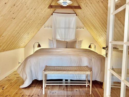 een slaapkamer met een groot bed met een houten plafond bij 6040-Stege-Rytsebaekvej-39 in Stege