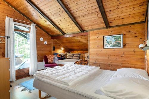 een slaapkamer met een groot bed in een kamer met houten wanden bij 3046-Stege-Paelen-46 in Stege
