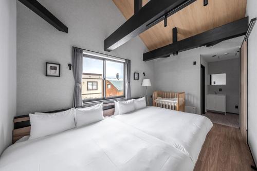a large white bed in a room with a window at Hoshiyado Higashikawa in Higashikawa