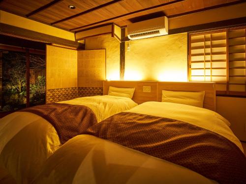 two twin beds in a room with a light at Tetsu-juro former Ogunis residence , Himeji Castles back parlor-like"400-year-old inn" in Fukusaki