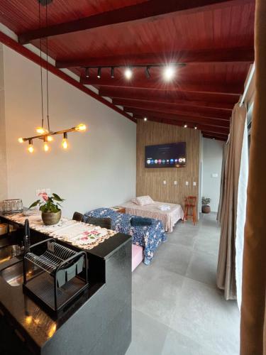 a living room with a bed and a table at Habitación Maninha in Pântano Grande