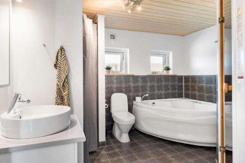 a bathroom with a tub and a toilet and a sink at OH449-Hadsund-Haslevgarde-Eng-49 in Hadsund