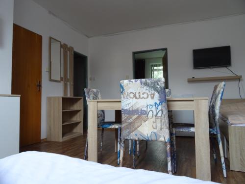 a room with a table and chairs and a television at Penzion Eden Turnov in Turnov