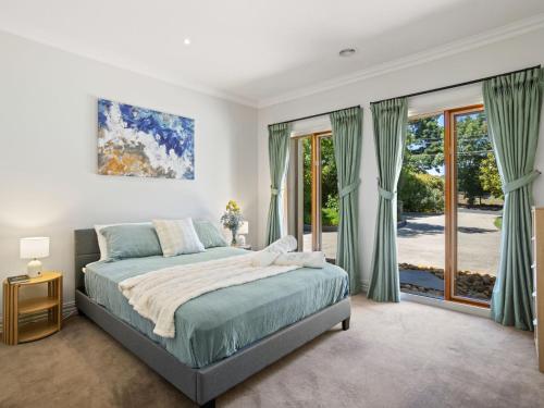 une chambre avec un lit et une grande fenêtre dans l'établissement Jacksons Coast House, à Mount Eliza