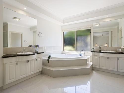 La grande salle de bains est pourvue d'une baignoire et de deux lavabos. dans l'établissement Jacksons Coast House, à Mount Eliza