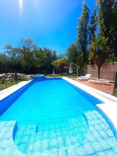 a large swimming pool with blue water at Shangri la - Casa y Pileta Privada in Mendoza