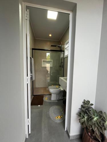 a bathroom with a toilet and a glass shower at Habitación Maninha in Pântano Grande