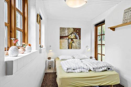 een slaapkamer met een bed in een witte kamer bij HA186-Saeby-Lynglund-6 in Sæby