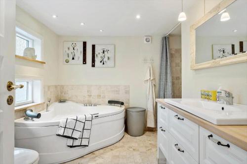 een witte badkamer met 2 wastafels, een bad en een toilet bij HA347-Saeby-Bjornborgvej-5 in Sæby