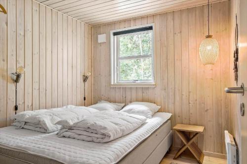 a bed in a corner of a room with a window at OH185-Hadsund-Sommerland-39 in Hadsund