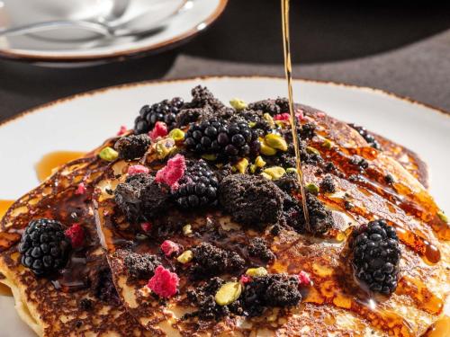 ein Teller Pfannkuchen mit Brombeeren und Sirup in der Unterkunft Sofitel Chicago Magnificent Mile in Chicago