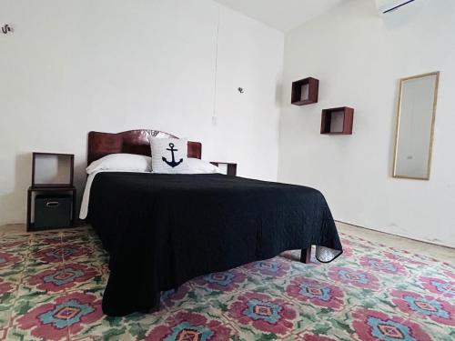 a bedroom with a bed with a black blanket at Casa Playa Blanca in Progreso