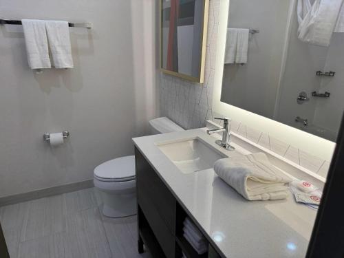 a bathroom with a sink and a toilet and a mirror at Comfort Inn & Suites Colby in Colby