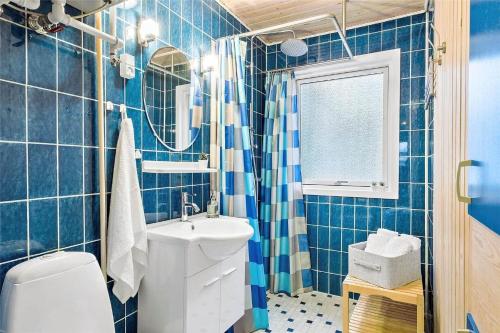 un bagno piastrellato blu con lavandino e WC di OH412-Hadsund-Halvrebene-94 a Hadsund