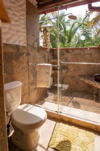 a bathroom with a toilet and a glass shower at Cabaña San Miguel in Moñitos