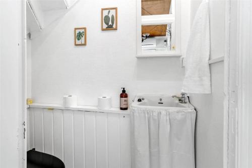 een witte badkamer met een wastafel en een spiegel bij OH409-Hadsund-Vesterled-2 in Hadsund