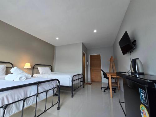 een hotelkamer met twee bedden en een televisie bij Khao Oat airport in Nai Yang Beach