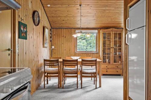 een keuken met een tafel, stoelen en een koelkast bij HA306-Asaa-Strandgardsvej-68 in Aså