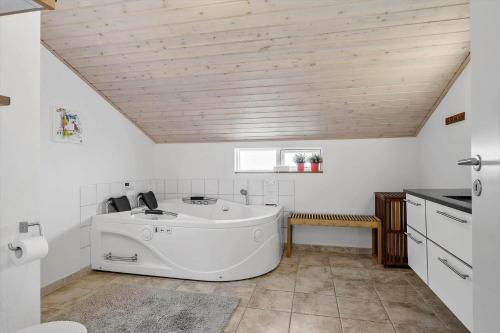 een wit bad in een keuken met een houten plafond bij HA173-Asaa-Knirren-6-B in Aså