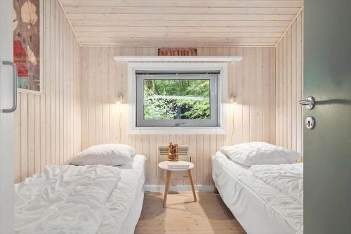 una piccola camera da letto con due letti e una finestra di HA178-Hals-Lyngtoftegaard-2 a Hals
