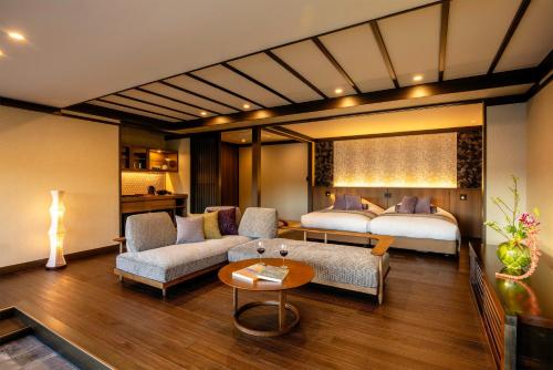 een hotelkamer met twee bedden en een woonkamer bij まち宿 壱龍 MACHIYADO ICHIRYU in Takayama